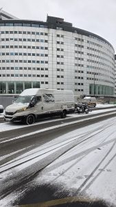 Camion de débarras professionnel circulant sous la neige pour assurer un service continu malgré les conditions hivernales.
