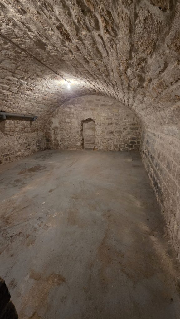 Grande cave voûtée en pierre après débarras complet dans un immeuble ancien du 6ᵉ arrondissement de Paris