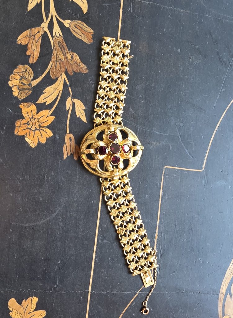 Bracelet ancien en métal précieux doré avec cabochons rouges monté sur une large maille décorative